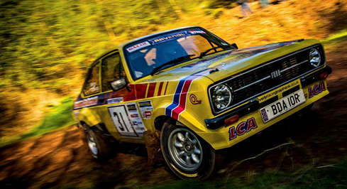 yellow rally car on dirt forest track