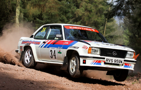 White rally car kicking up dirt cloud